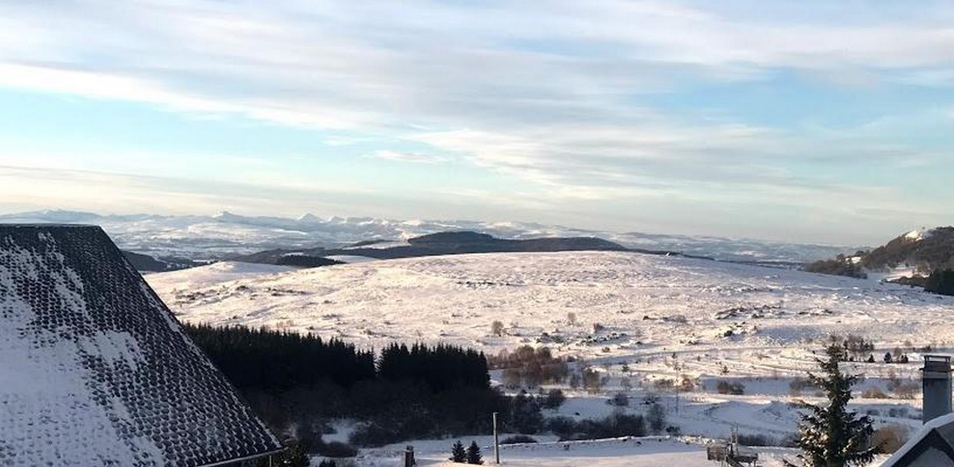 Chalet avec vue sur les monts du Cantal sous la neige à Super Besse